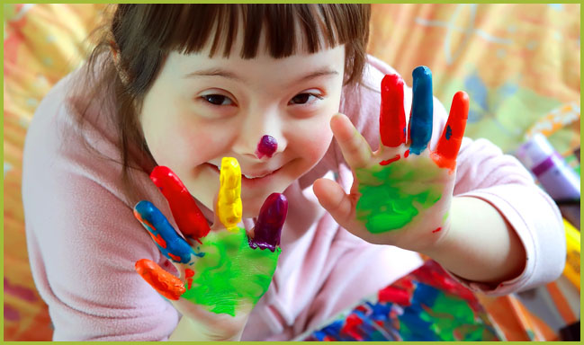 little girl showing fingerpainted hands and nose
