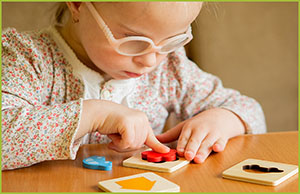child wearing glasses and working on a puzzle