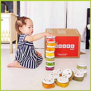 Girl stacking square baby meals