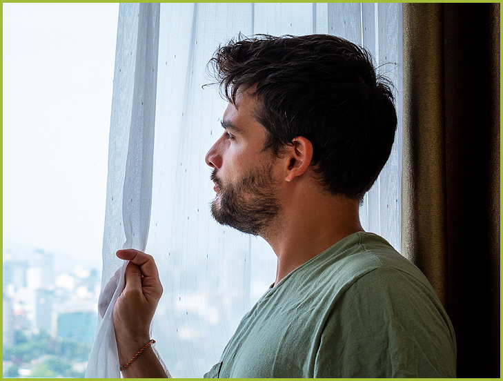 man looking out window