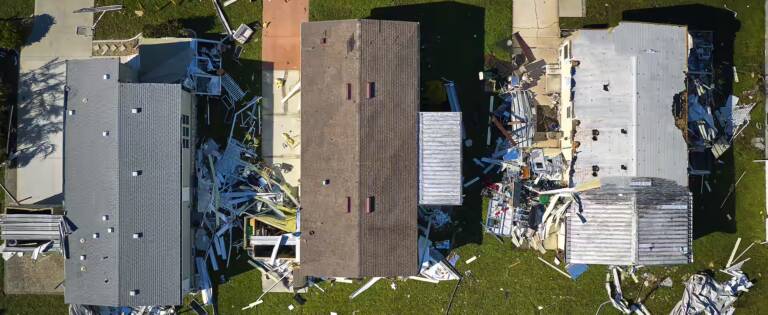 overhead view of three mobile homes damaged by recent storm