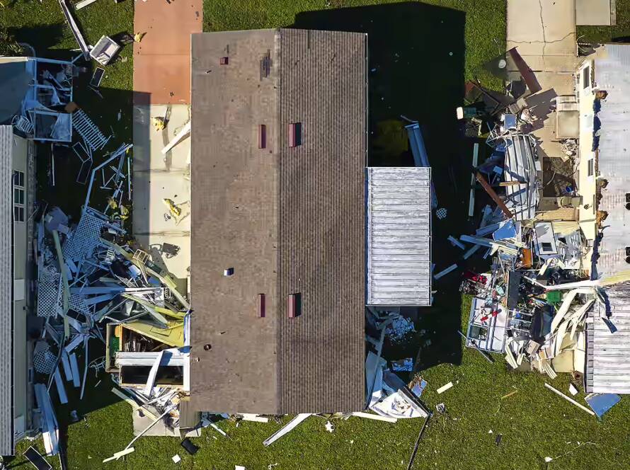 overhead view of three mobile homes damaged by recent storm