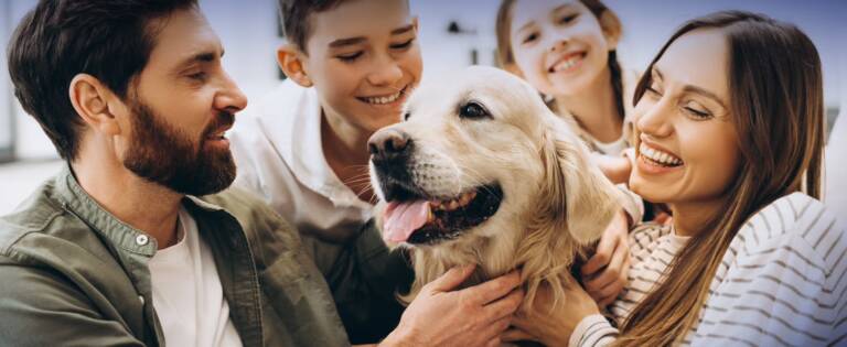 Family gathered around petting their dog